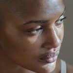 A photo of a black woman with clear bare skin