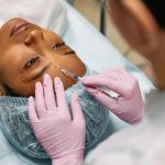 A black woman receiving an injectable beauty treatment