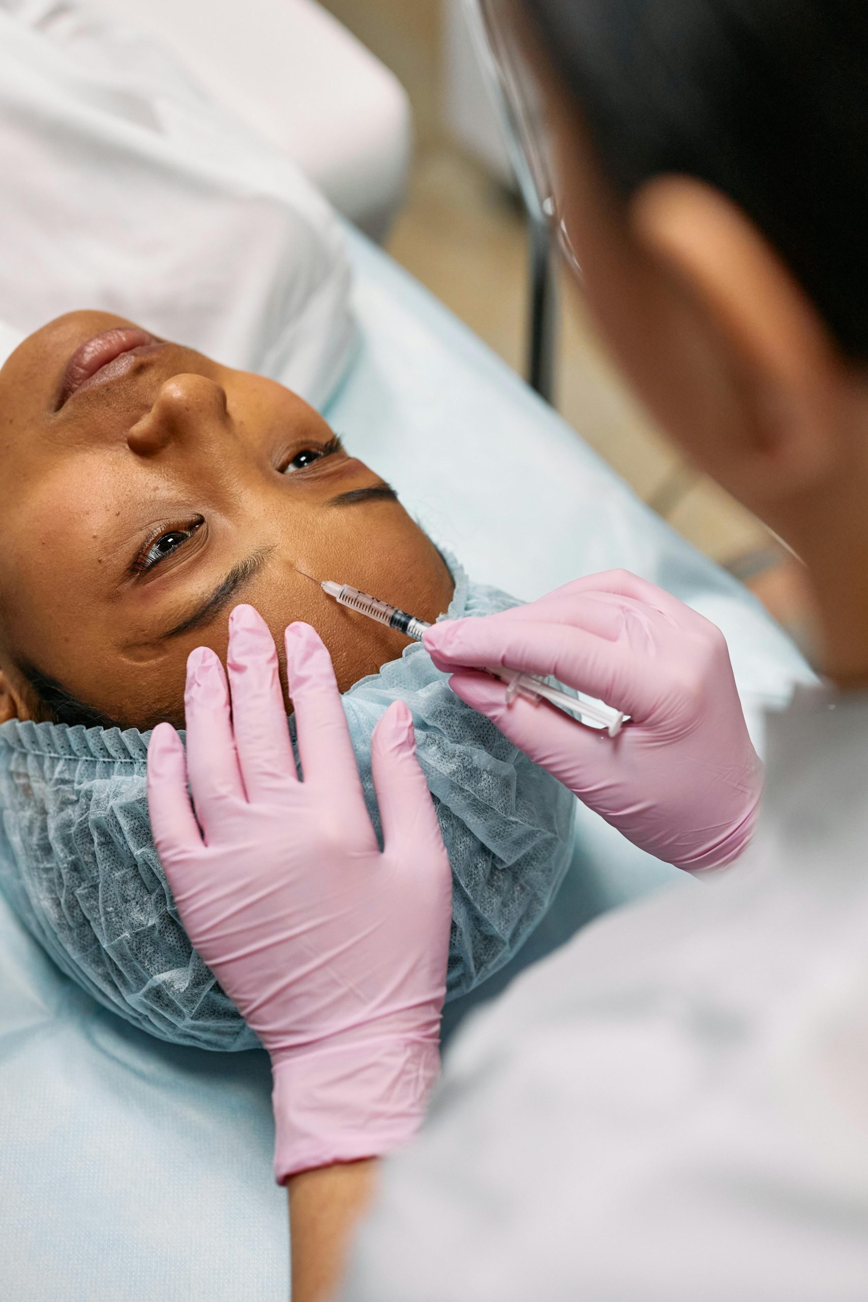 A black woman receiving an injectable beauty treatment